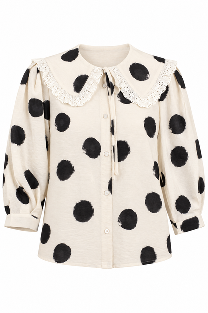 An off-white long-sleeve blouse with black polka dots, featuring a lace-trimmed Peter Pan collar and a front button closure.