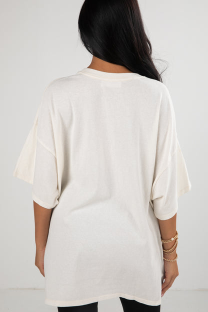 Person wearing a white oversized t-shirt against a plain background