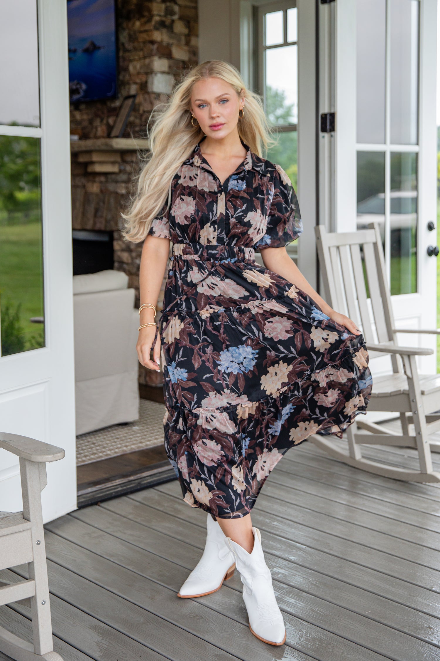 Woman in a floral dress standing on a porch