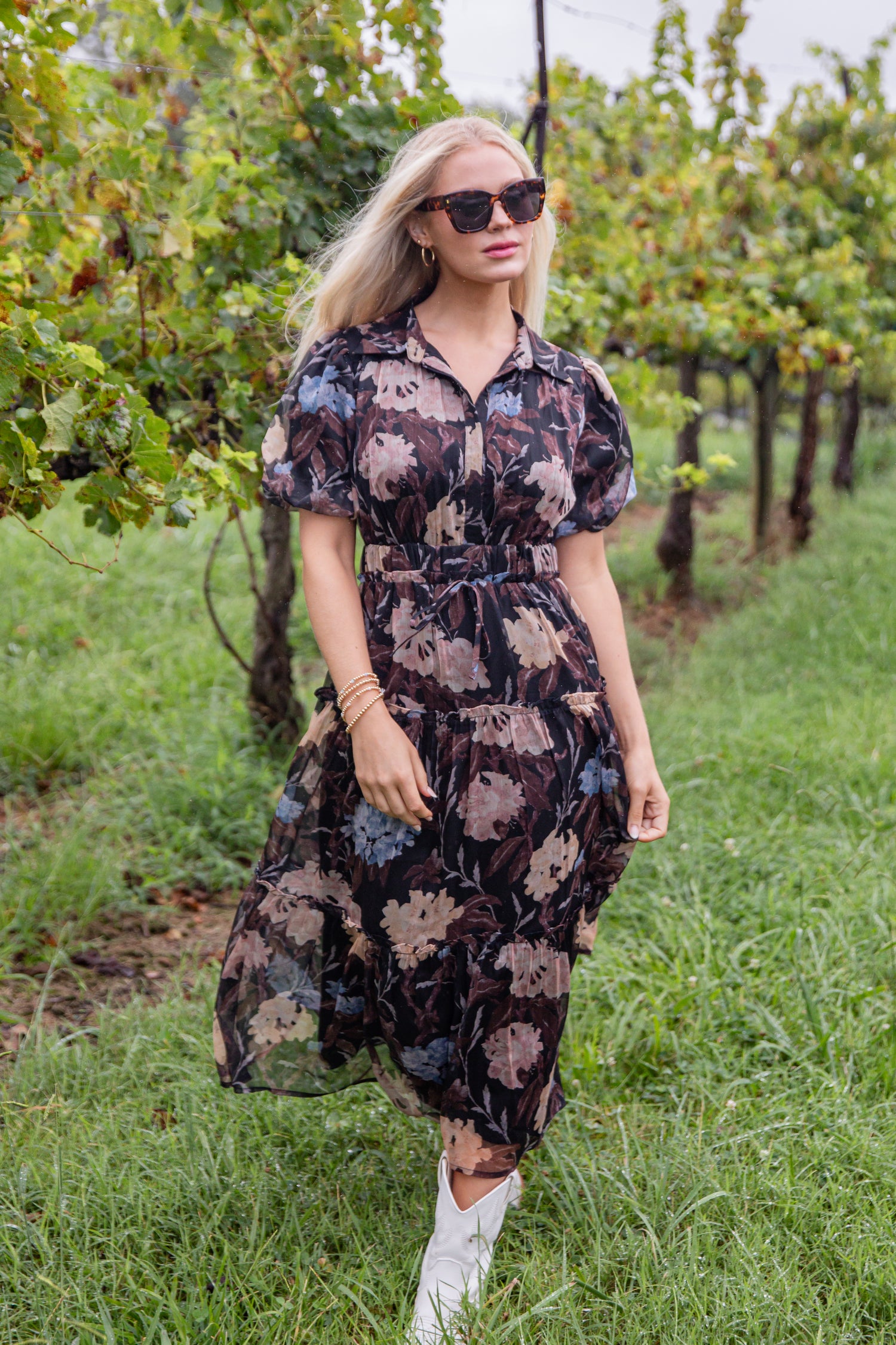 Woman in a floral dress standing in a vineyard