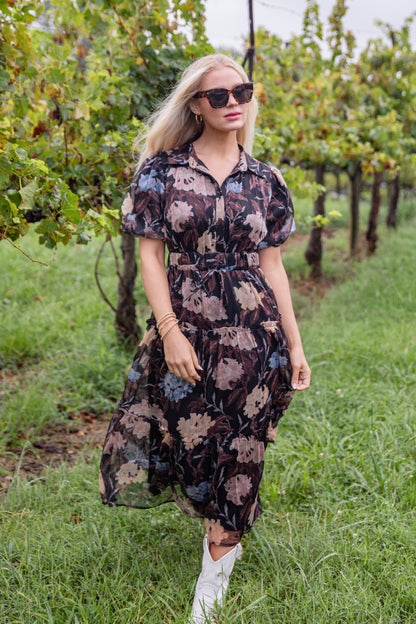Woman in a floral dress standing in a vineyard