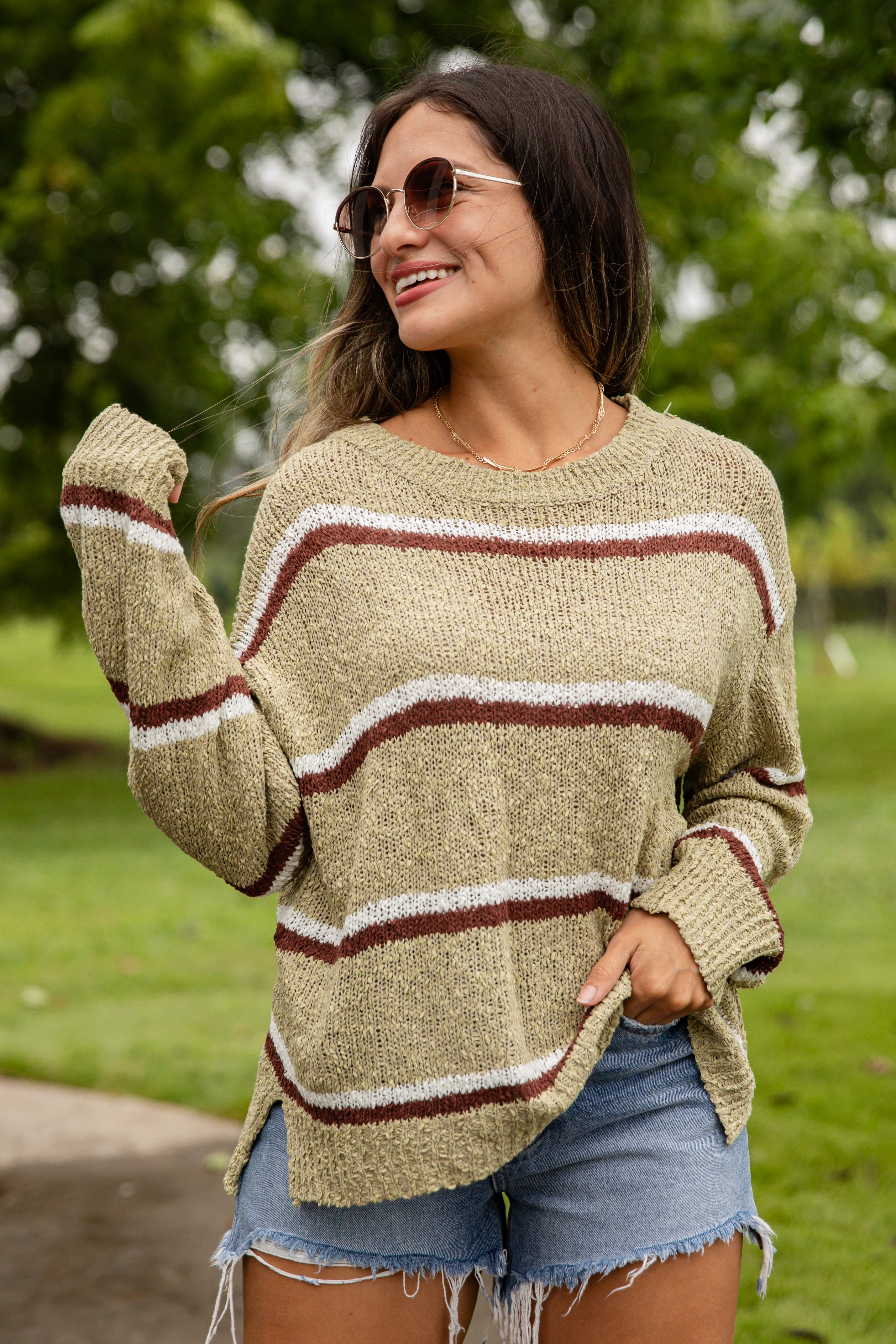 Woman wearing a striped sweater and sunglasses outdoors