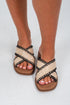 Woven sandals with black straps worn by a person on a light background
