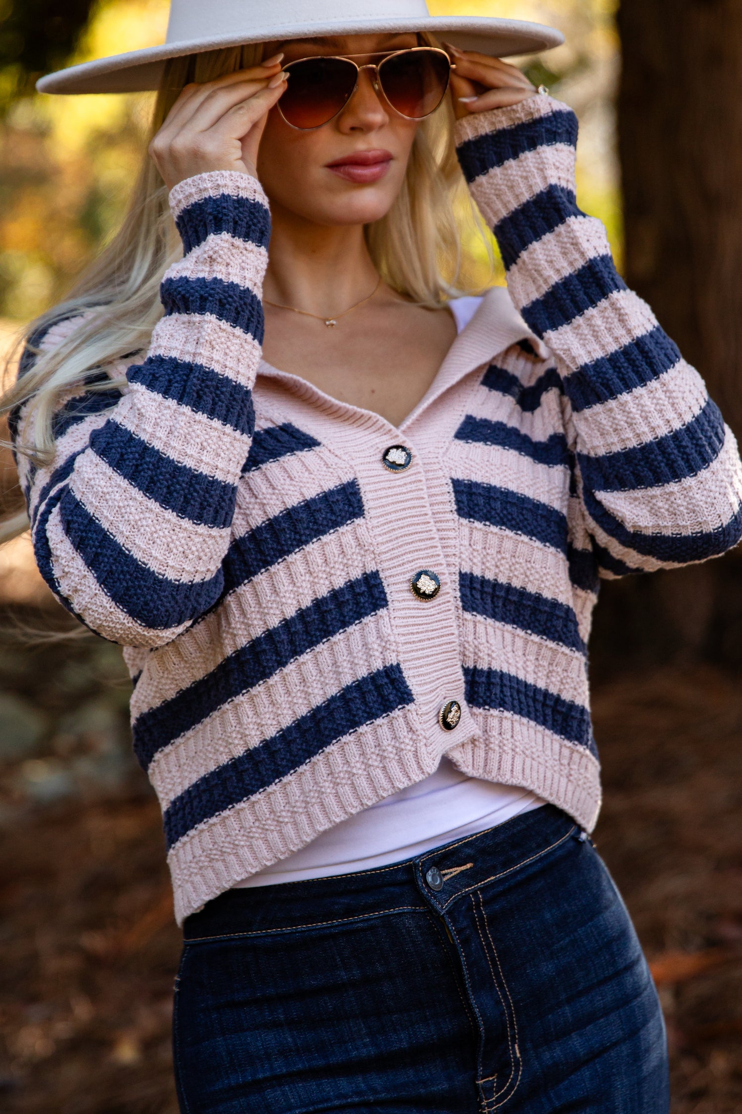 Woman wearing a striped cardigan with a blurred natural background