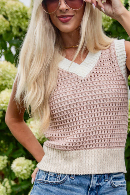 Woman wearing a pink crochet top with a white collar against a green background