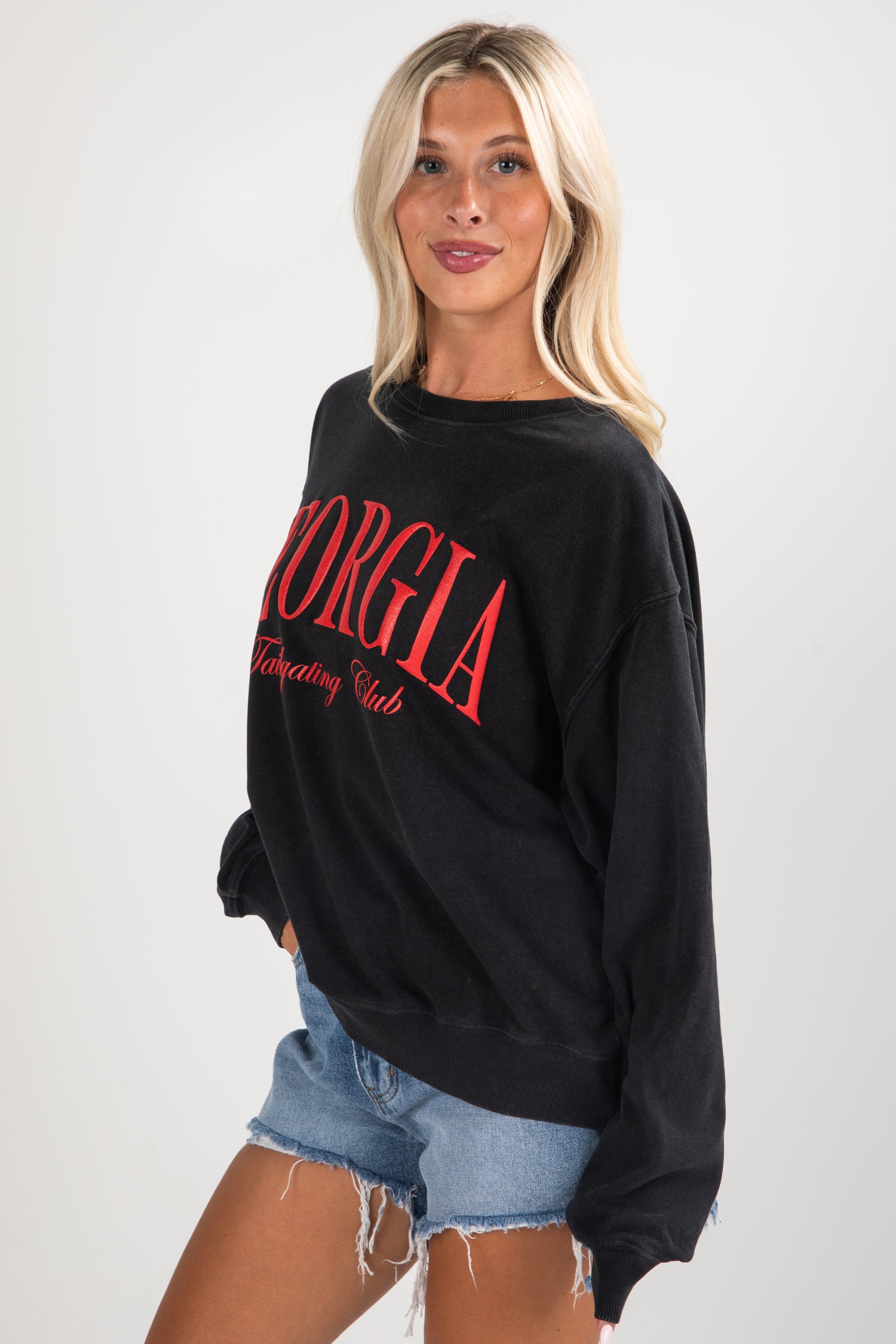 Woman wearing a black sweatshirt with red text on a white background