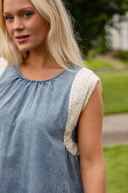 Woman wearing a blue dress with lace details outdoors