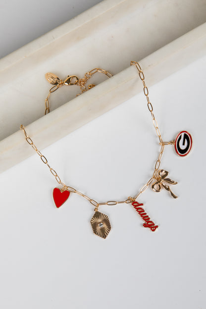 Gold bracelet with various charms on a white surface