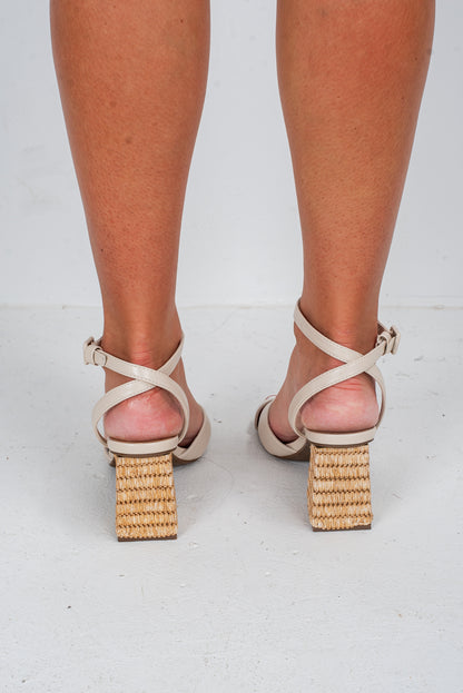 Beige high-heeled sandals with woven block heels on a white background