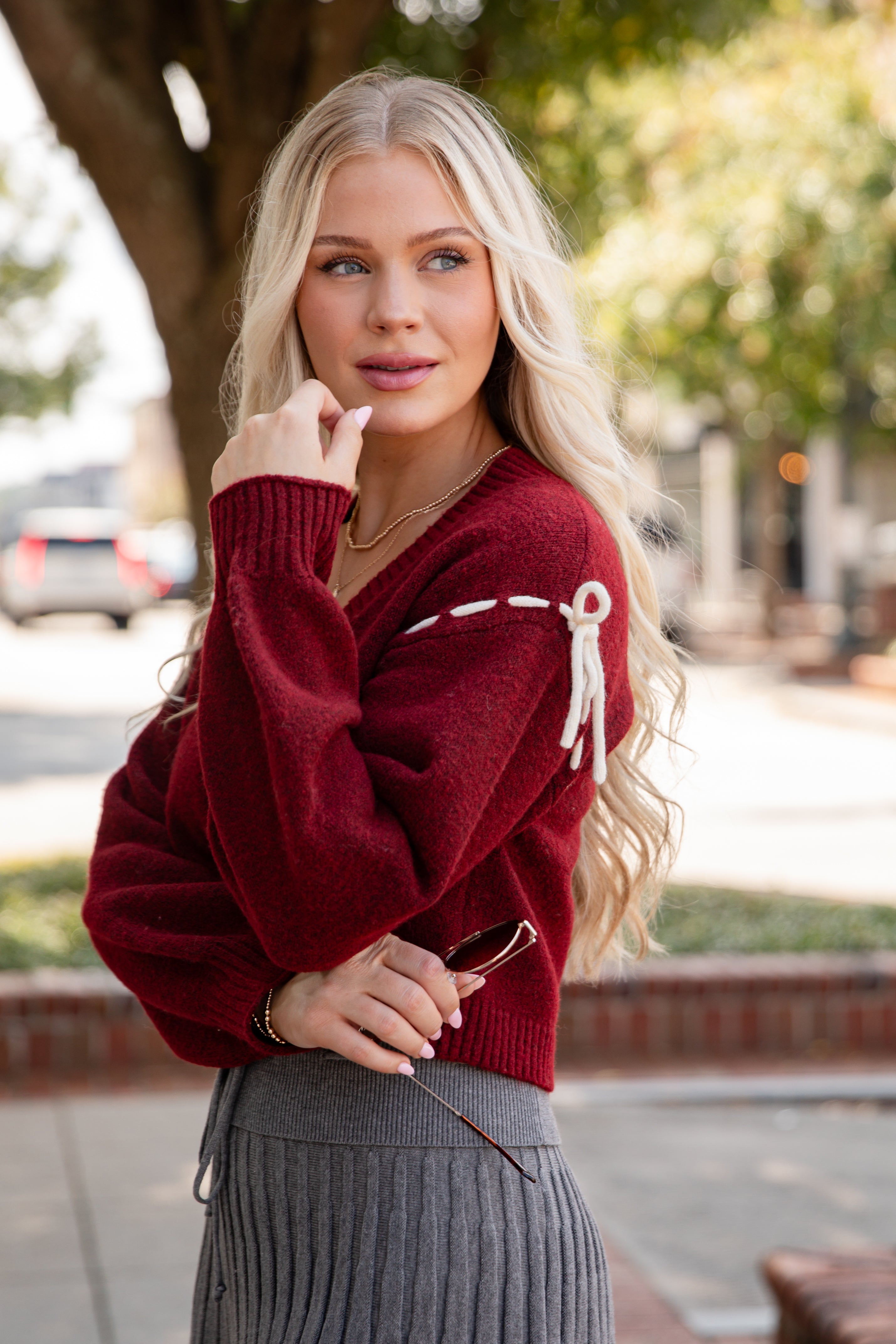 Woman wearing a red sweater with white patterns outdoors