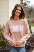 Woman wearing a pink sweater with &
