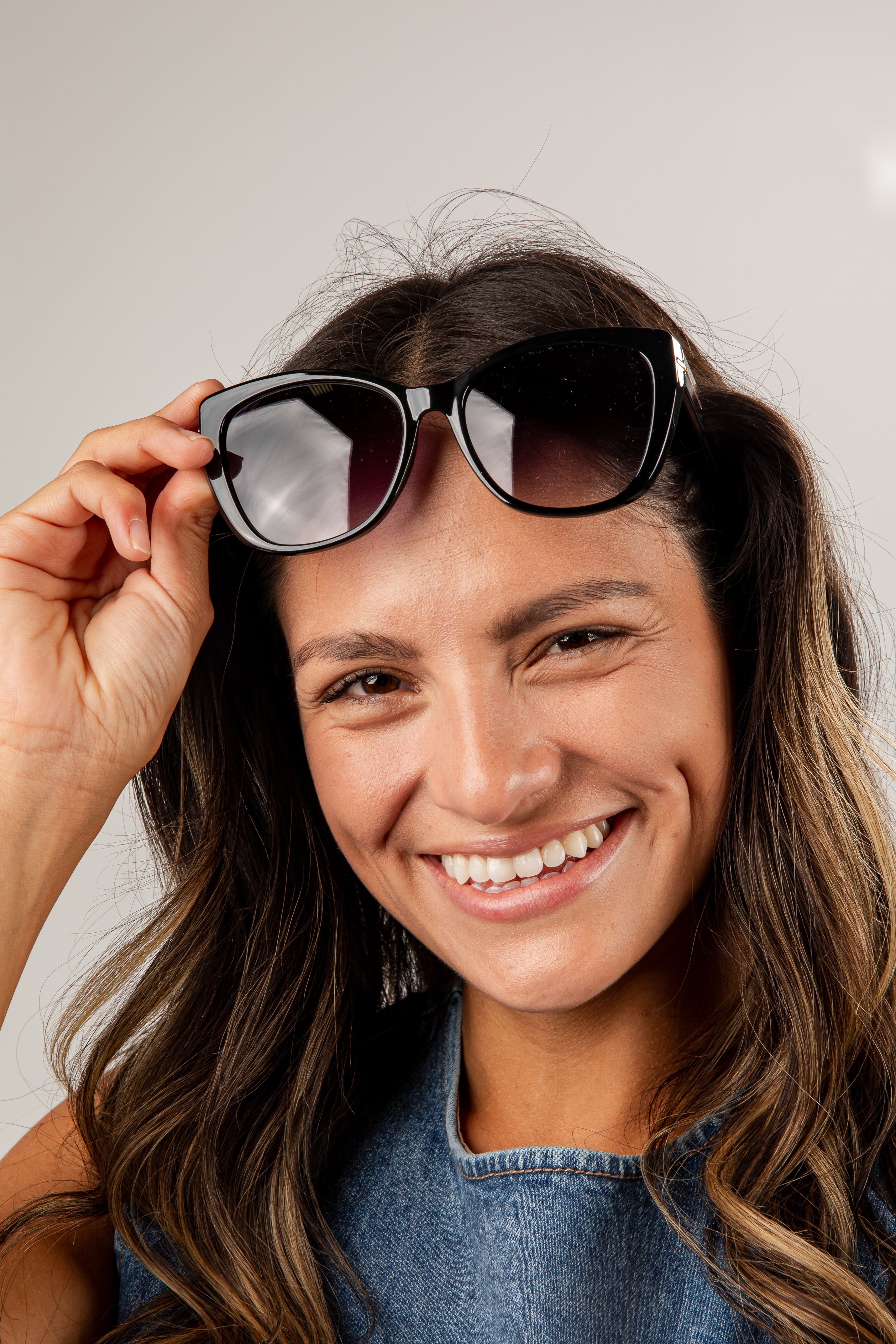Woman wearing sunglasses with a neutral background