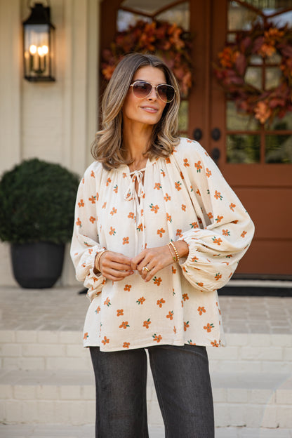 Woman wearing a floral blouse and sunglasses outdoors