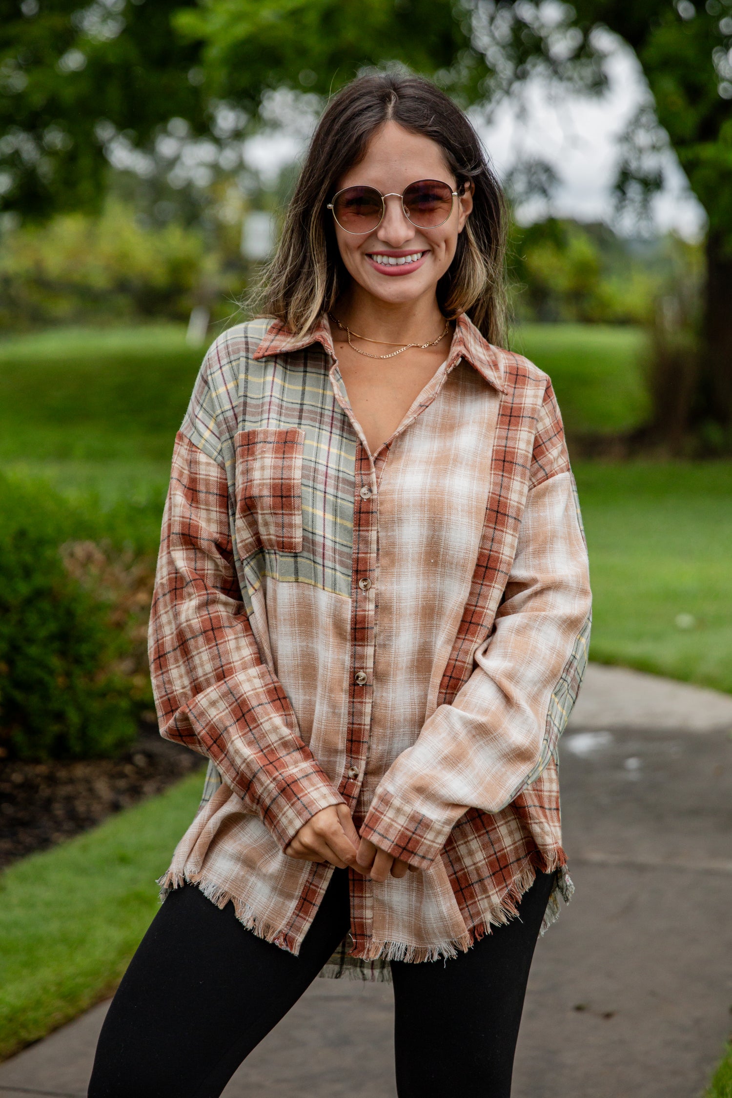 Woman wearing a plaid shirt and sunglasses outdoors