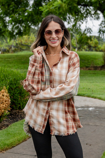 Woman wearing a plaid shirt outdoors on a sunny day