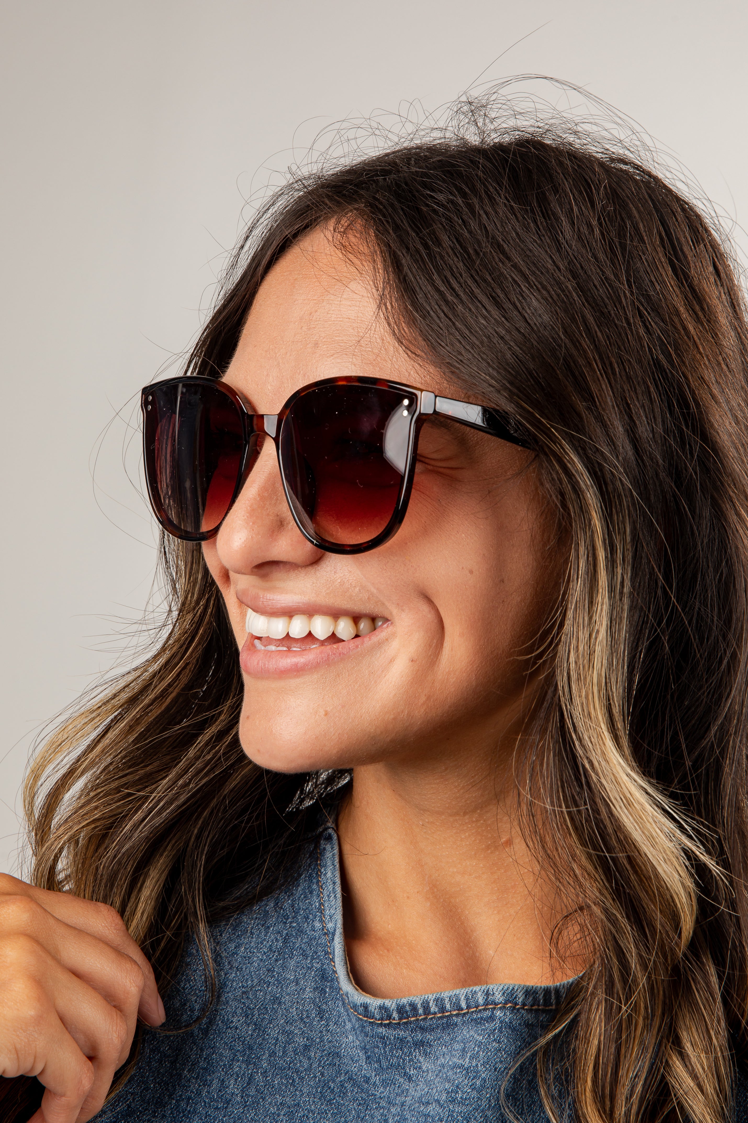 Woman wearing sunglasses with a neutral background