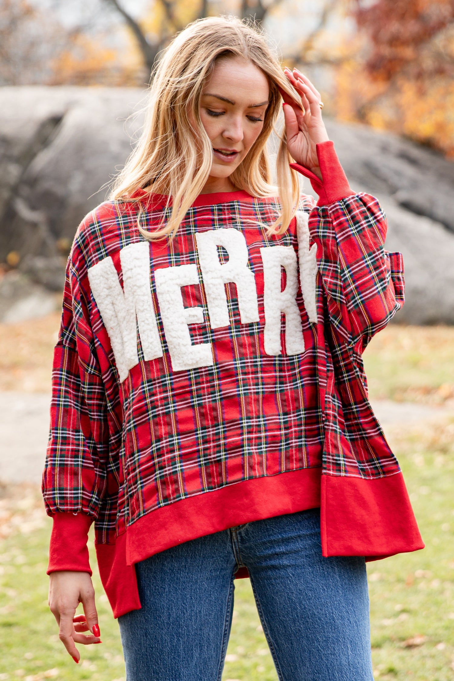 Woman wearing a red plaid sweater with &