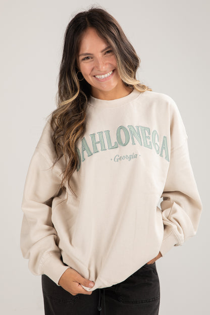 Woman wearing a beige sweatshirt with &