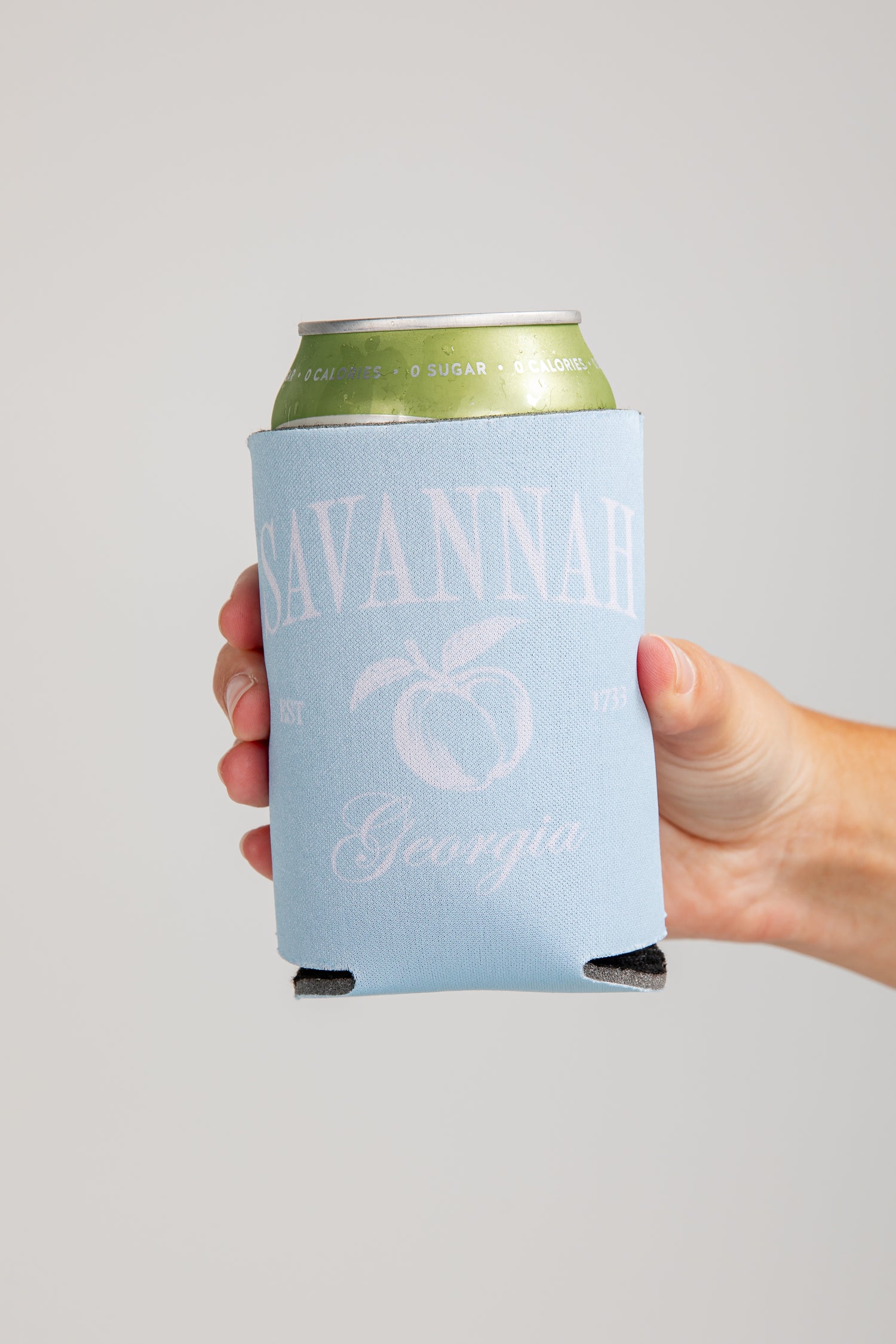 Hand holding a can with a &