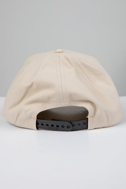 Beige cap with a black adjustable strap on a light gray background