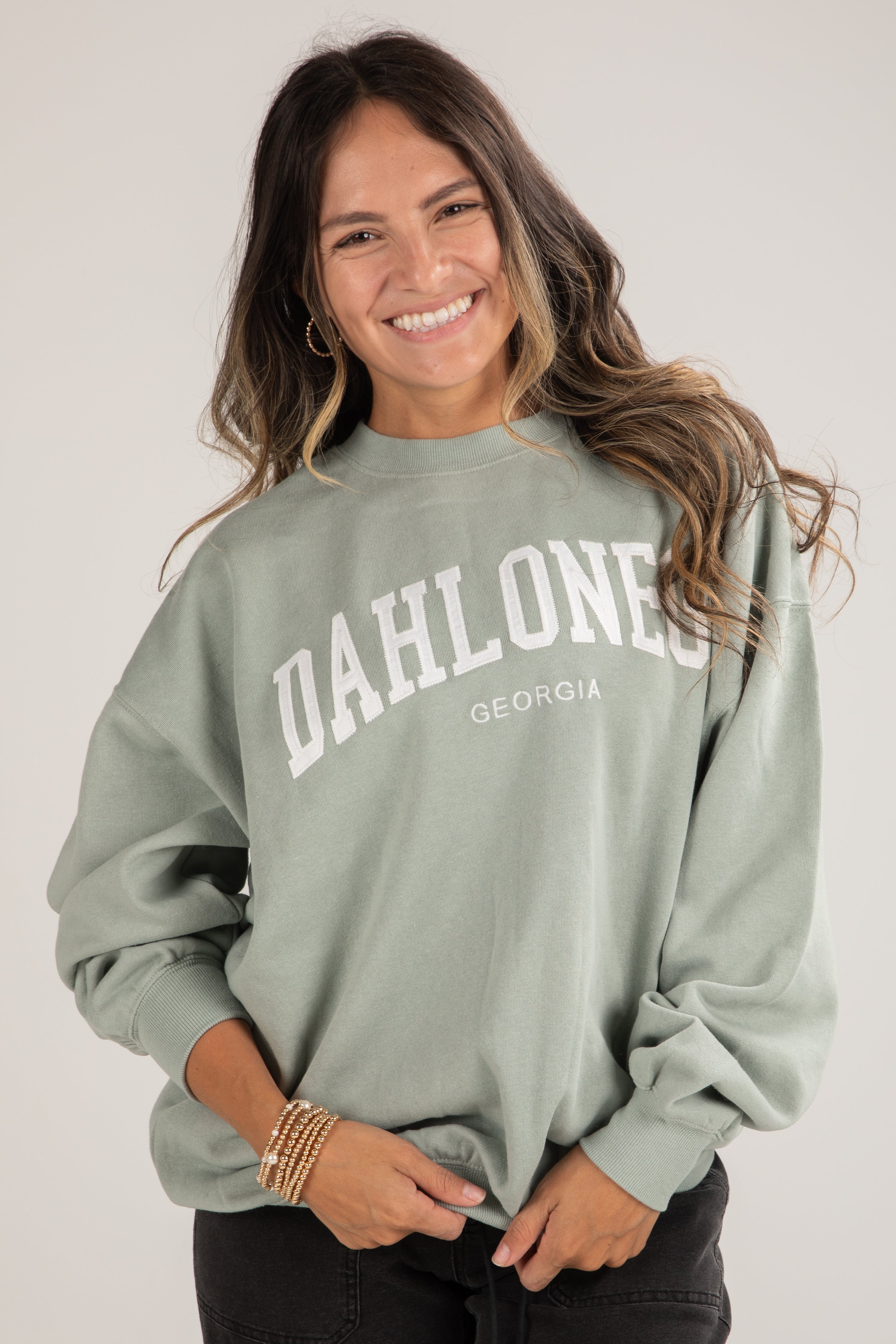 Woman wearing a green sweatshirt with &