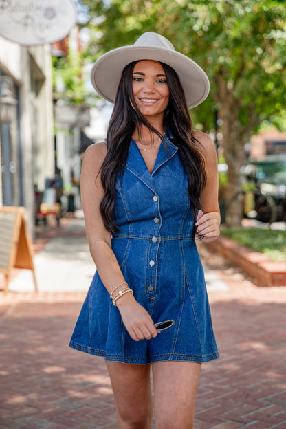 Woman wearing a denim dress and white hat on a street