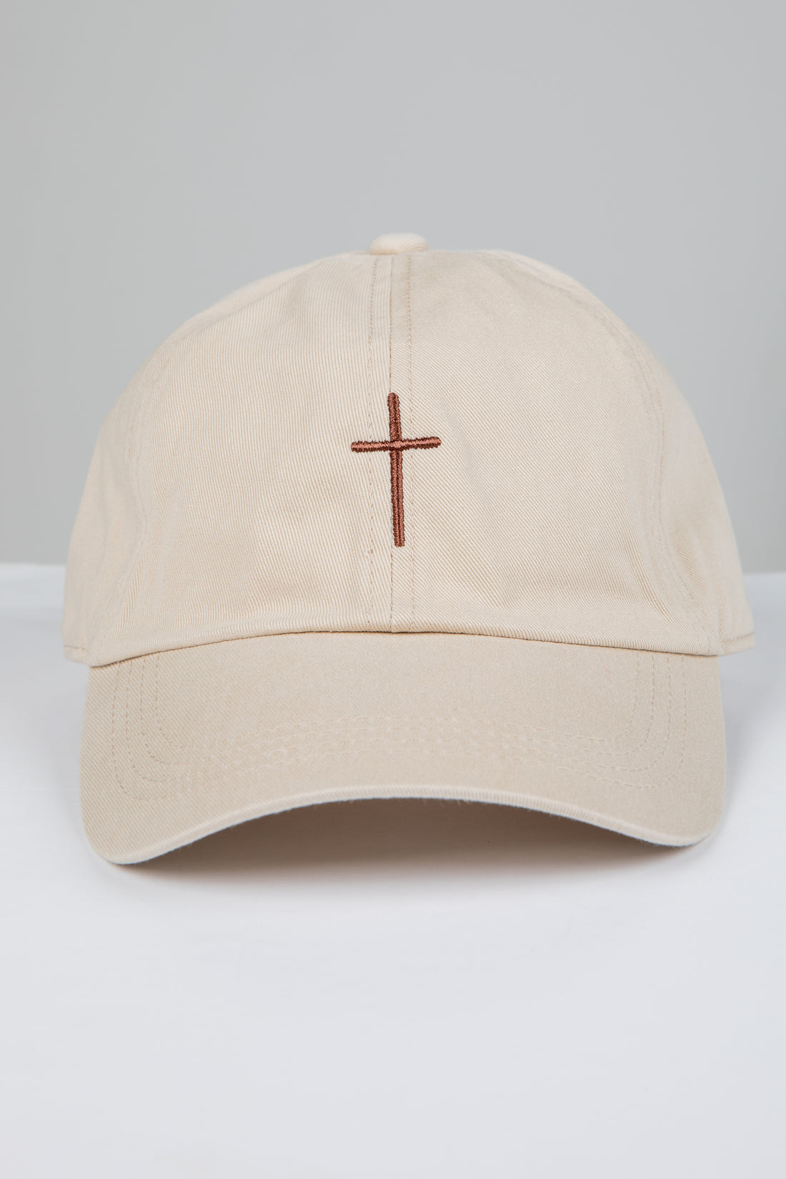 Beige cap with a brown cross on a white background