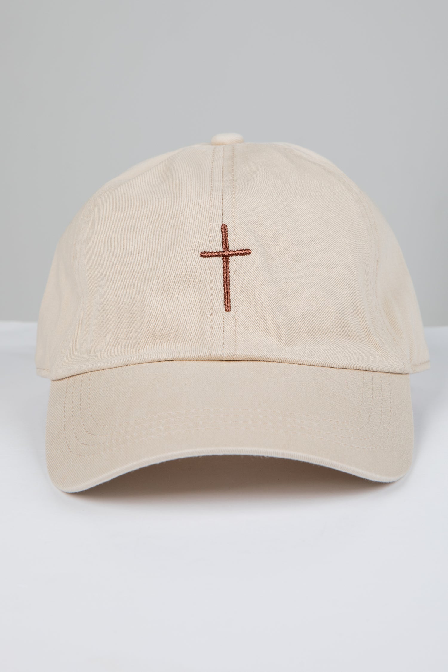 Beige cap with a brown cross on a white background