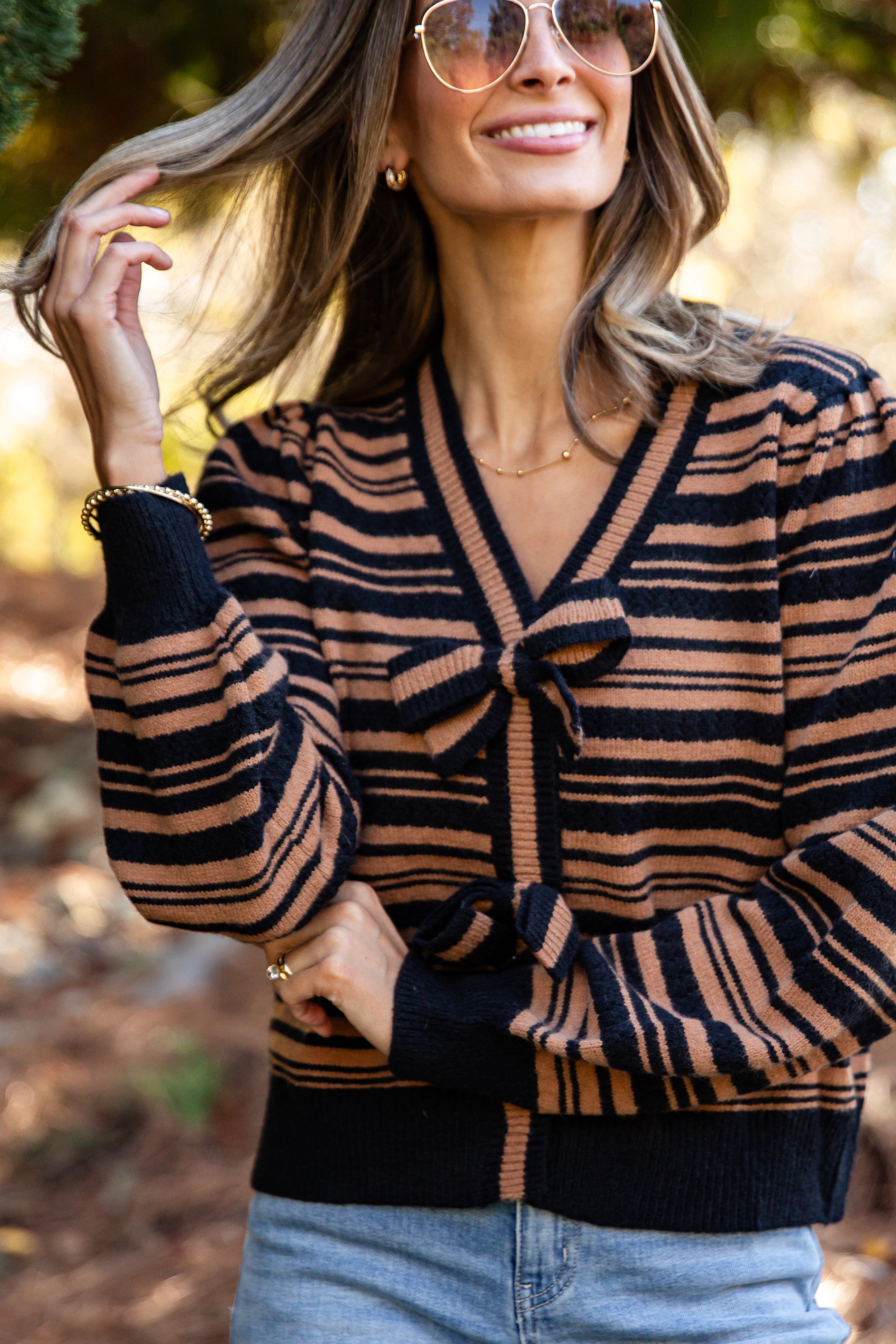 Woman wearing a striped sweater with a blurred natural background