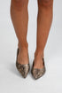 Snake print pointed-toe shoes worn by a person on a white background