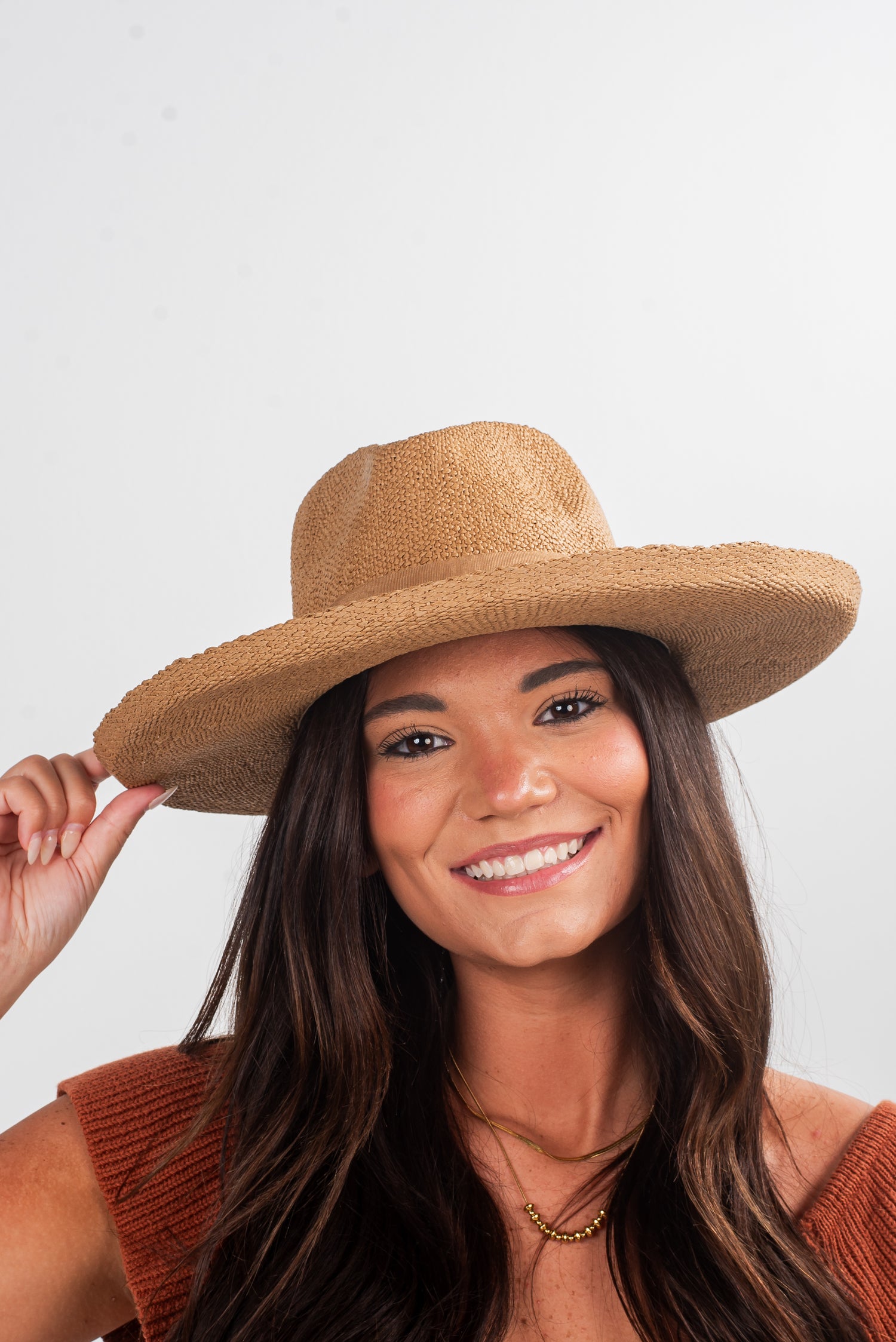 Woman wearing a straw hat against a plain background
