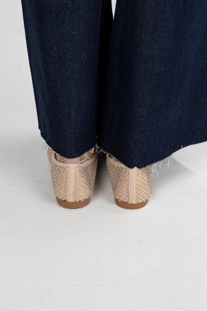 Navy pants with beige woven shoes on a white background
