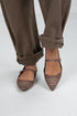Brown checkered shoes worn with brown pants on a white background
