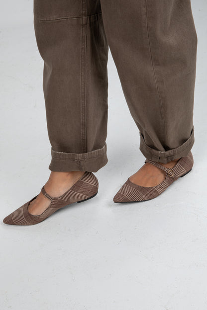 Brown pants and patterned flats on a white background