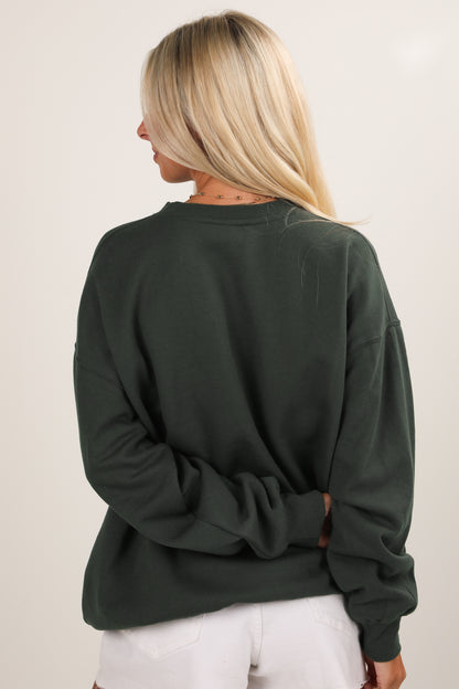 Person wearing a green sweatshirt with a plain background