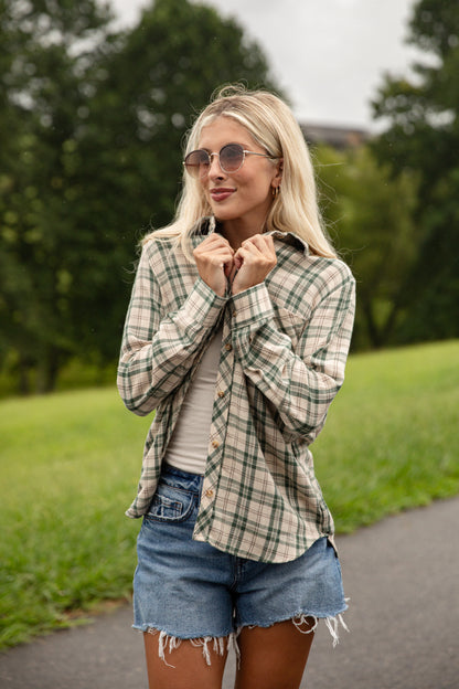 Woman wearing a plaid shirt and denim shorts outdoors