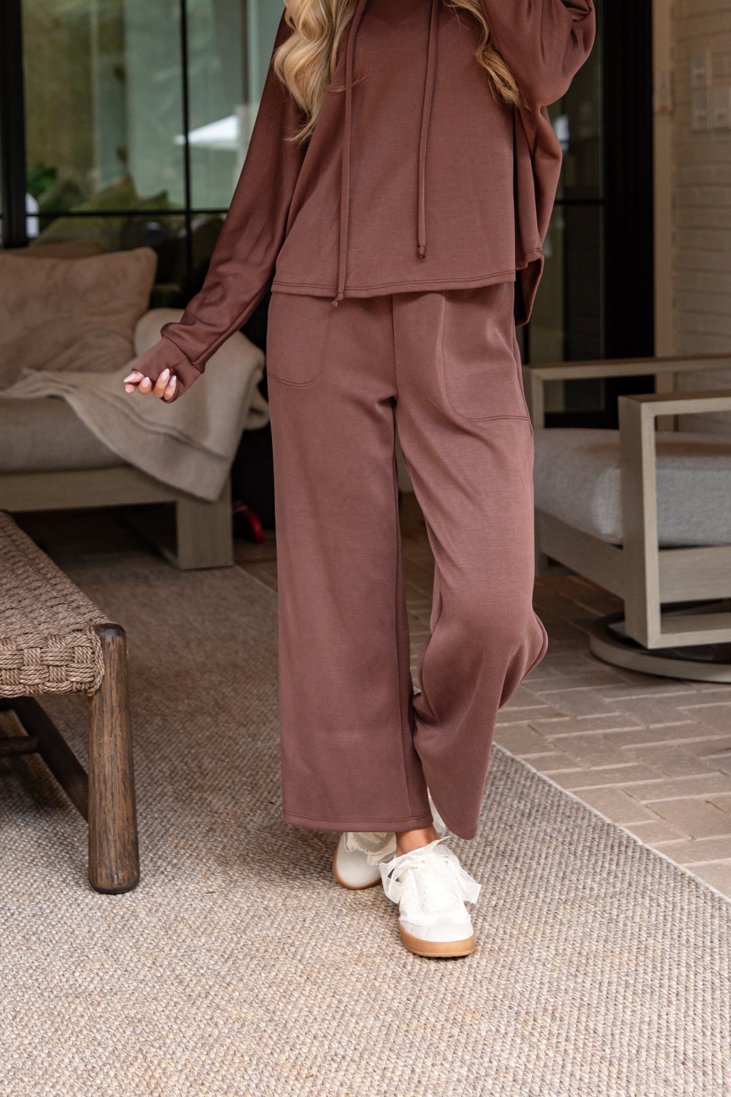 Person wearing a brown tracksuit in an indoor setting