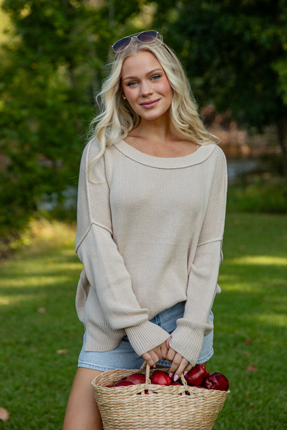 Woman holding a basket of apples in an outdoor setting