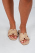 Beige sandals worn on feet with a light background