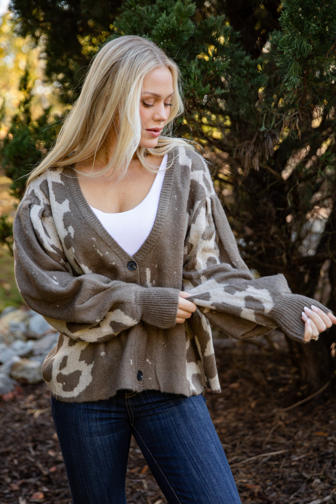 Woman wearing a camouflage-patterned cardigan outdoors