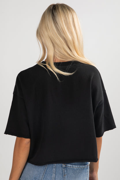 Person wearing a black oversized t-shirt and blue jeans on a white background