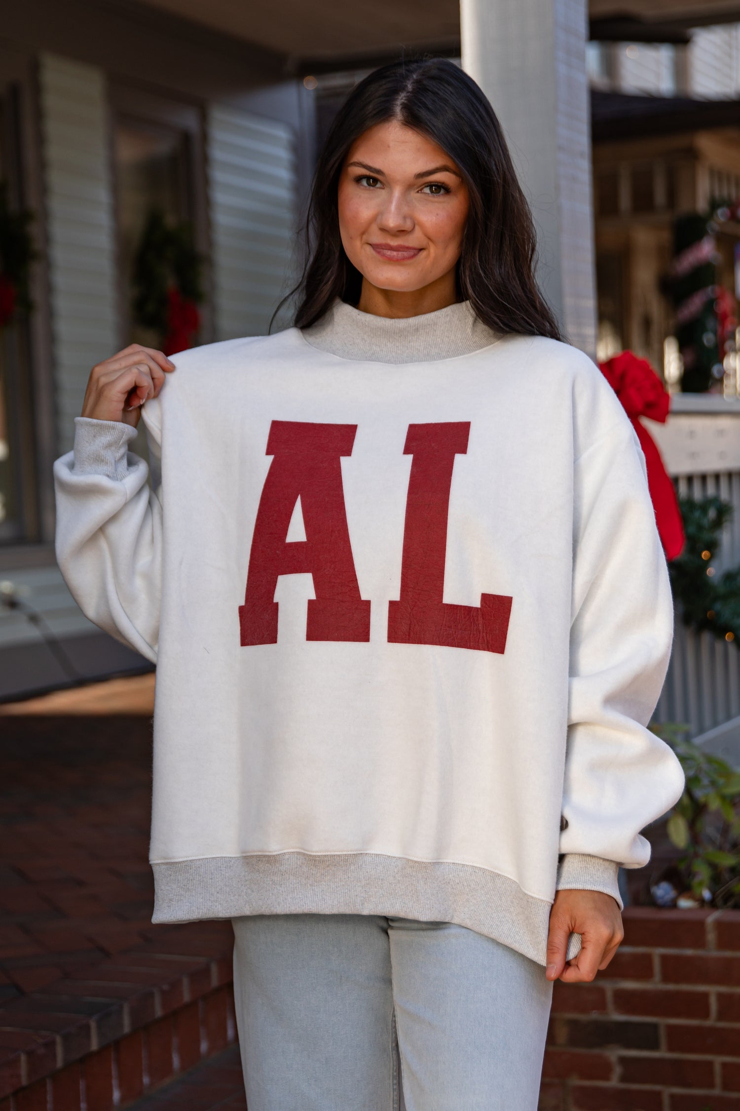 Woman wearing a white sweater with &