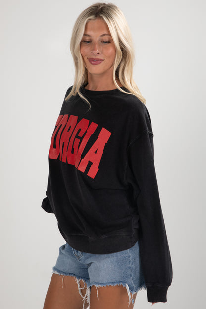 Woman wearing a black sweatshirt with red text on a plain background