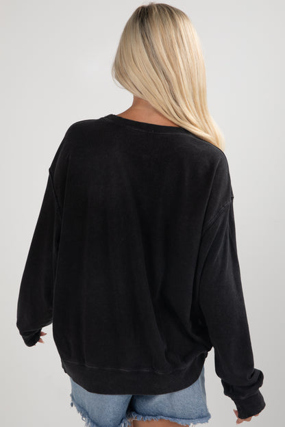 Person wearing a black oversized sweatshirt on a plain background