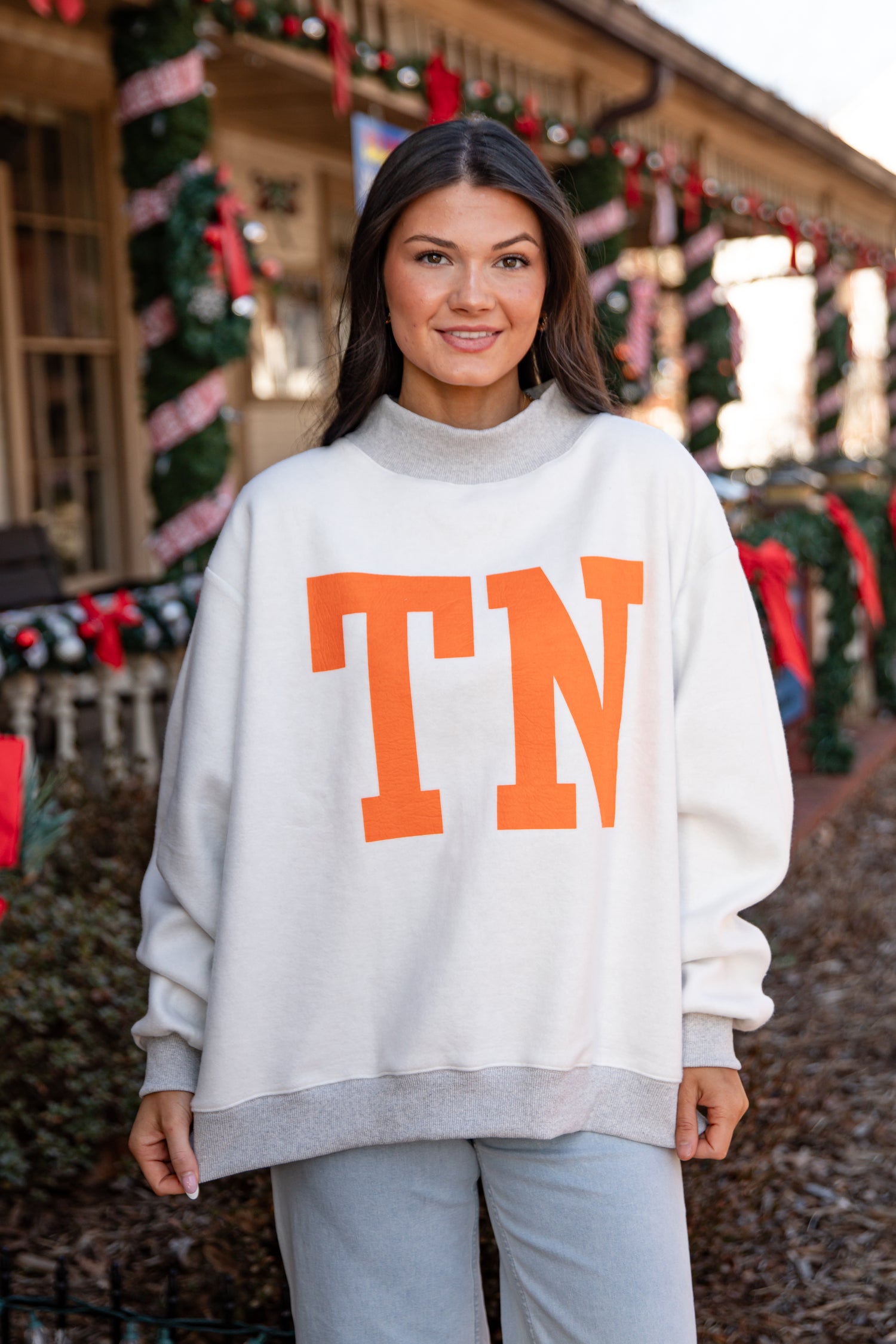 Woman wearing a white sweater with &