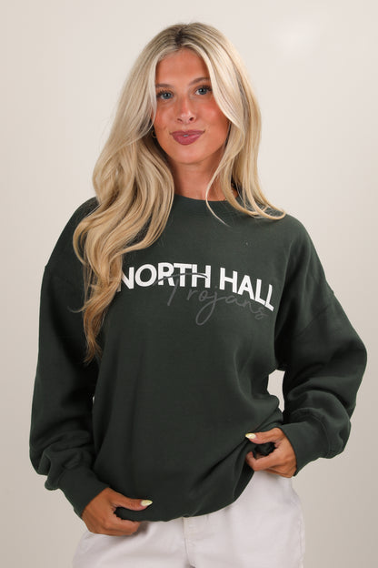 Woman wearing a dark green sweatshirt with &