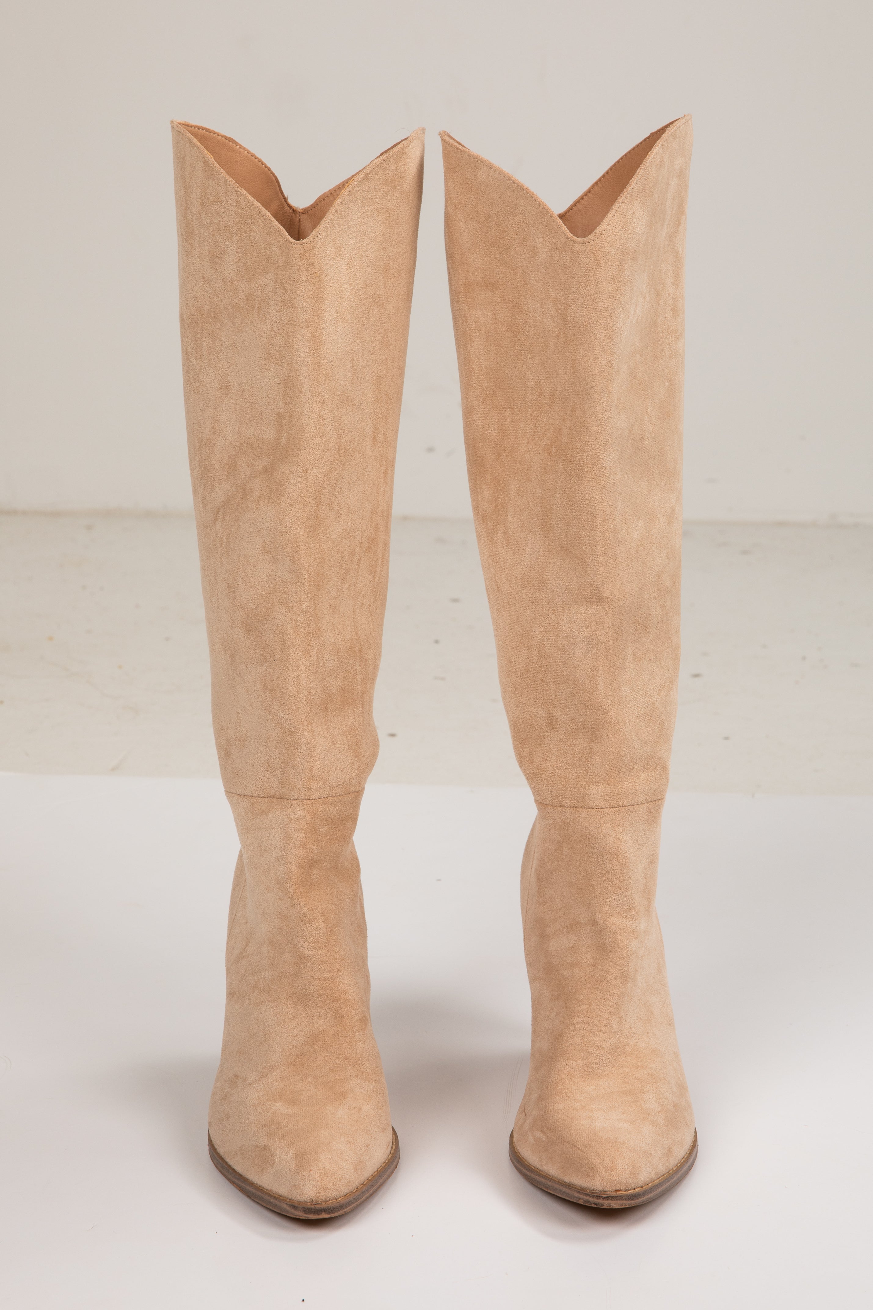 Pair of beige knee-high boots on a white background