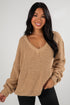 Woman wearing a beige knitted sweater against a white background