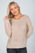 Woman wearing a beige sweater against a plain background