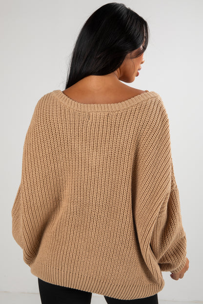 Woman wearing a beige knitted sweater against a white background